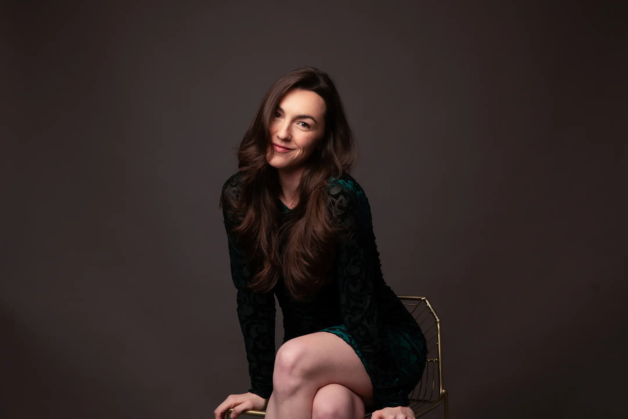 Lauren Scudder seated in a dark green velvet dress